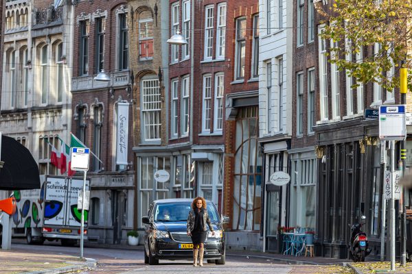 Uitvaartleidster loopt voor de rouwauto Uitvaartleidster loopt voor de rouwauto, afscheidsfotografie, Dordrecht binnenstad